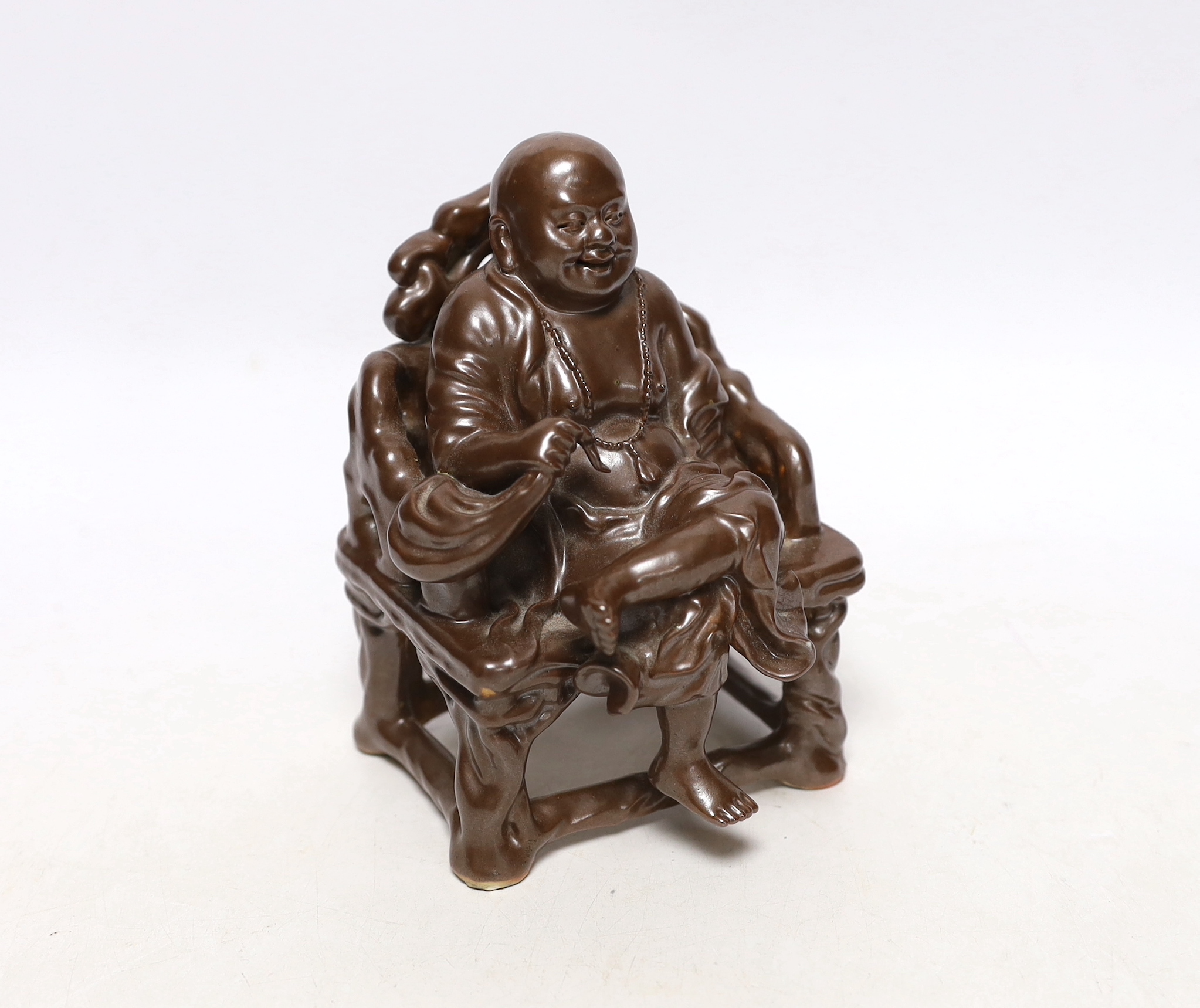 A late 19th/ early 20th century Chinese porcelain faux bronze figure of Budai seated on a throne, 15cm high, Provenance - Owned by the same family prior to 1980.